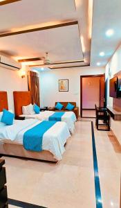 a hotel room with three beds and a piano at Stillers Residency in Rahimyar Khan