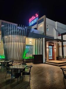 a restaurant with tables and chairs in front of a building at Stillers Residency in Rahimyar Khan