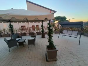 a patio with tables and chairs and a large umbrella at Residence Hill in San Quirico dʼOrcia