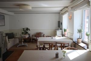 a restaurant with tables and chairs in a room at Hotell Bäckagården in Ystad