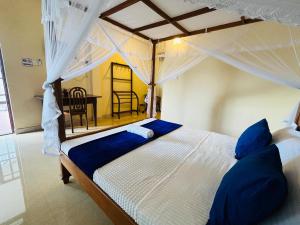 a bedroom with a large bed with blue pillows at Nature's Crest Resort in Urulewatta