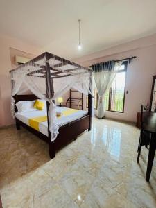 a bedroom with a large bed with a canopy at Nature's Crest Resort in Urulewatta