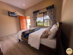a bedroom with a large bed and a window at Nhacuene's place in Vilanculos