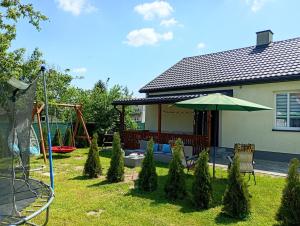a yard with a playground and an umbrella at Noclegi u Franciszka in Trzebiesza