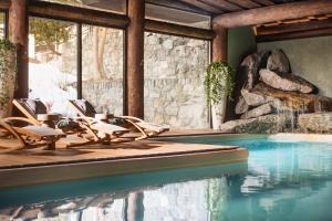 a pool with chaise lounge chairs and a swimming pool at Hotel Flüela Davos - The Unbound Collection by Hyatt in Davos