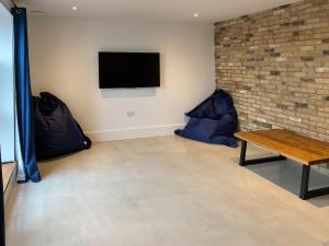 a room with a table and a tv on a wall at Glenvar in Falmer