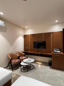 a living room with a couch and a table and a tv at Hotel M Stayz Sirsa in Sirsa +26 photos