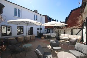 a patio with tables and chairs and umbrellas at Hotell Bäckagården in Ystad +48 photos