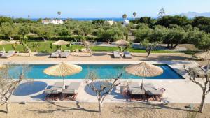 a resort with a swimming pool with umbrellas at Ta Spitakia in Kos