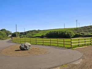 a rock on the side of a road next to a fence at Tir Deri in Llanrian