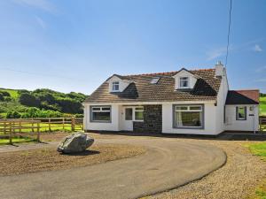 a house with a rock in front of it at Tir Deri in Llanrian