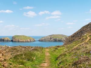 a path leading to two islands in the ocean at Tir Deri in Llanrian