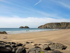 a beach with rocks and the ocean with two cliffs at Tir Deri in Llanrian +17 photos