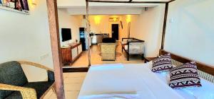 a bedroom with a bed and a living room at Diani White Sands in Diani Beach +13 photos