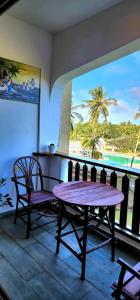 a table and chairs on a balcony with a view of the beach at Diani White Sands in Diani Beach