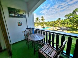 a balcony with a table and chairs and a view of the ocean at Diani White Sands in Diani Beach