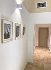a hallway with three pictures on the wall at Somnium Vitae - Casa Vacanze in Montescaglioso