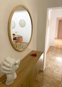 a mirror on a wall above a dresser in a room at Somnium Vitae - Casa Vacanze in Montescaglioso