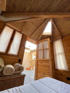 a bedroom with a wooden ceiling with windows and a bed at Taida Chalet - Glamping in Villa de Leyva