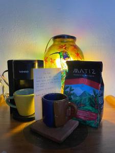a table with a cup of coffee and a jar of milk at Taida Chalet - Glamping in Villa de Leyva