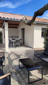 a patio with a table and chairs in front of a house at La petite maison de la Drôme in Aouste-sur-Sye +10 photos