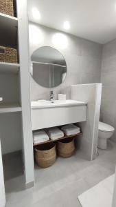 a bathroom with a sink and a mirror and a toilet at La petite maison de la Drôme in Aouste-sur-Sye