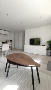 a living room with a table and a tv at La petite maison de la Drôme in Aouste-sur-Sye