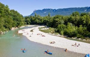 a group of people on a beach in a river at La petite maison de la Drôme in Aouste-sur-Sye