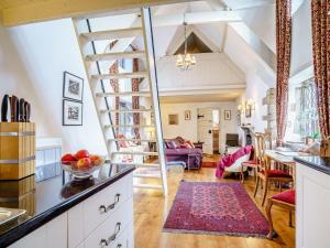 a kitchen and living room with a spiral staircase at Welsh Gatehouse A Historic Castle Retreat that Welcomes Dogs and Electric Vehicles in Mathern