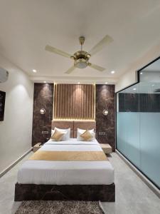 a bedroom with a large bed with a ceiling fan at Hotel M Stayz Sirsa in Sirsa