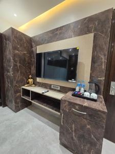 a bathroom with a tv on a wall with a counter at Hotel M Stayz Sirsa in Sirsa