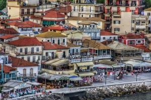 eine Gruppe von Gebäuden auf einem Hügel mit einer Stadt in der Unterkunft Old Parga Studios in Parga + 1 Foto