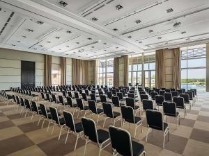 a large room with rows of chairs and a podium at Sofitel La Reserva Cardales in Río Luján +263 photos