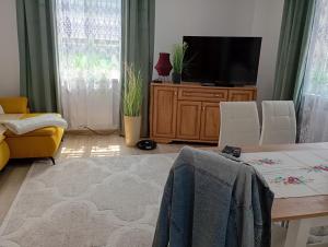 a living room with a television and a table and chairs at Noclegi u Franciszka in Trzebiesza
