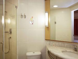 a bathroom with a shower and a toilet and a sink at ibis Uberlandia in Uberlândia +51 photos