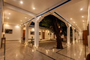 a hallway with a tree in the middle of a building at The Apricot Tree Hotel in Nūrla