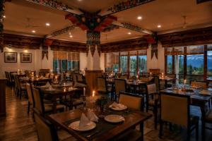 a dining room with tables and chairs and windows at The Apricot Tree Hotel in Nūrla