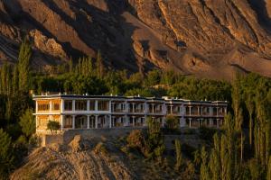 a building in front of a mountain at The Apricot Tree Hotel in Nūrla