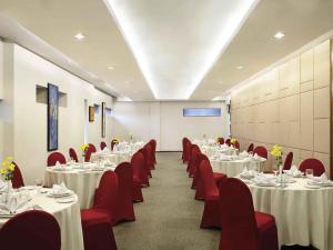 a banquet hall with white tables and red chairs at Ibis Styles Solo in Solo +29 photos