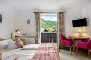 a bedroom with a bed and a desk and a window at Gästehaus Tanneck mit Hallenbad in Reit im Winkl +178 photos