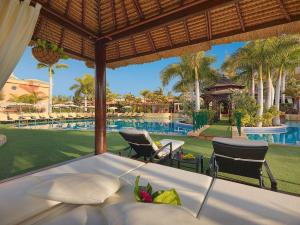 a resort bedroom with a view of a swimming pool at Green Garden Eco Resort in Playa de las Americas