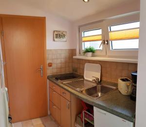 a small kitchen with a sink and a counter top at Ferienwohnung Graf Strandgut in Karlshagen +2 photos