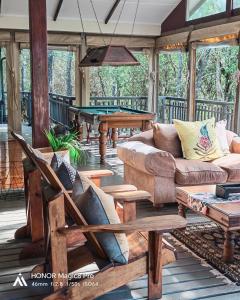 a porch with a couch and a pool table at Thornwood in Hluhluwe
