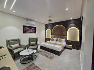 a hotel room with a bed and two chairs at Hotel M Stayz Sirsa in Sirsa