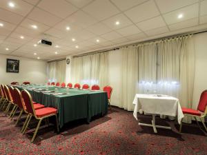 a conference room with a long table and red chairs at ibis Tlemcen in Tlemcen