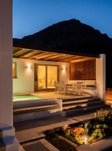 a villa with a swimming pool at night at Pefki Luxury Suites in Telendos