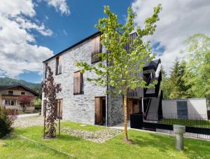 a brick house with a black roof at Aparthotel Chalina by Peak Stay in Leutasch
