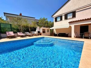 a swimming pool in front of a house at Apartments Zeljko B in Šilo
