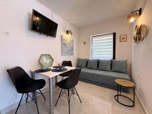a living room with a couch and a table and chairs at Apartments Zeljko B in Šilo