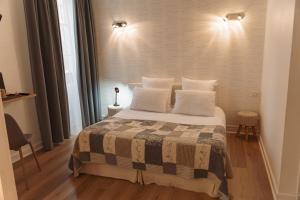 a bedroom with a large bed with white pillows at BRIT HOTEL Le Lion d'Or CHINON in Chinon +26 photos